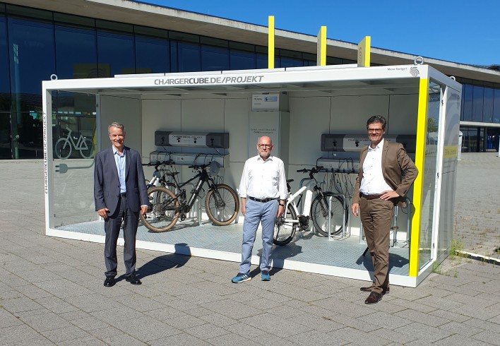 Landesverkehrsminister Winfried Hermann (M.) besucht die Ladestation für E-Bikes der Messe. Den Gast begrüßen die beiden Messegeschäftsführer, Roland Bleinroth (l.) und Stefan Lohnert.  